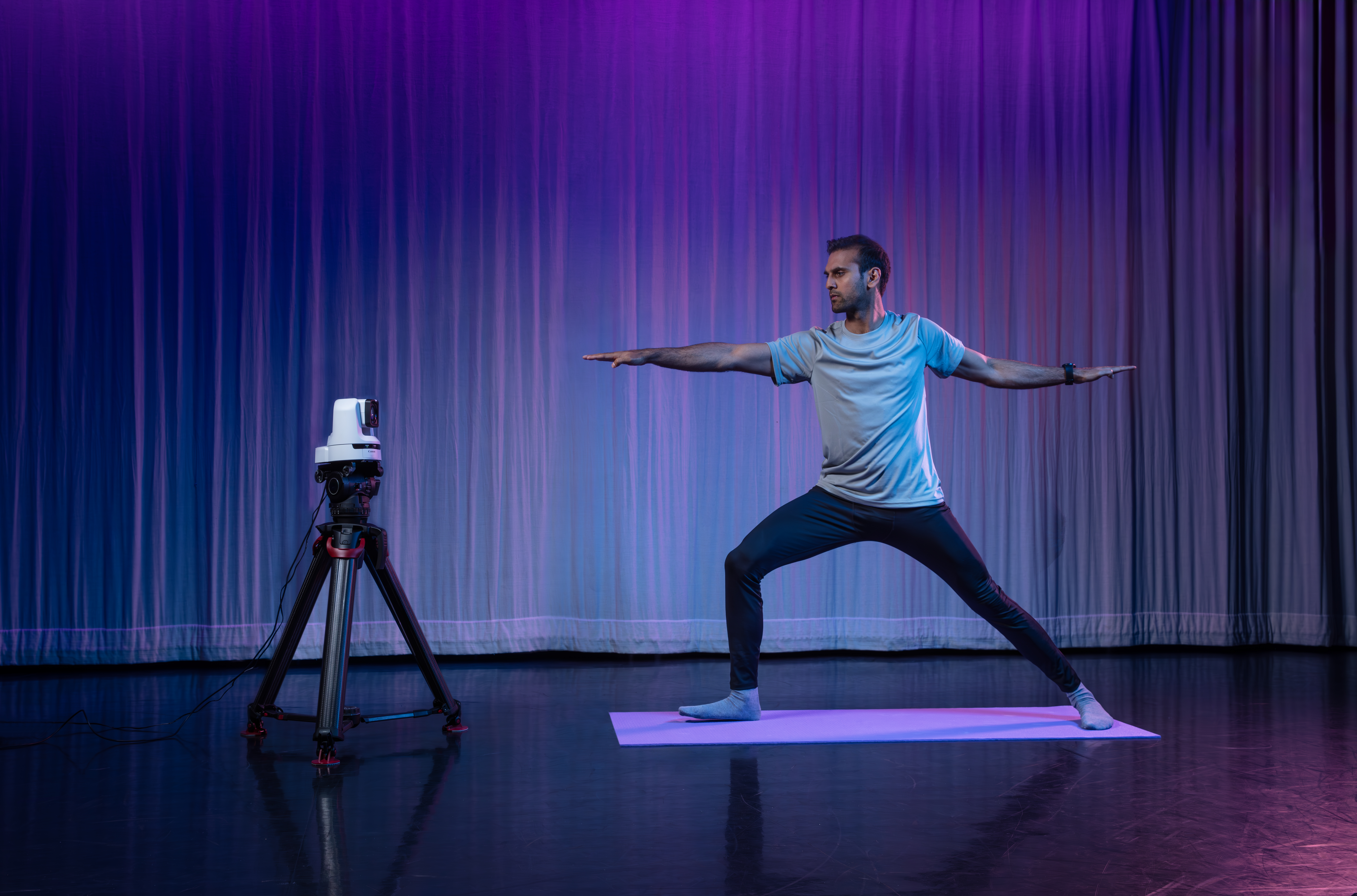 Mann macht Yoga vor einer PTZ Kamera